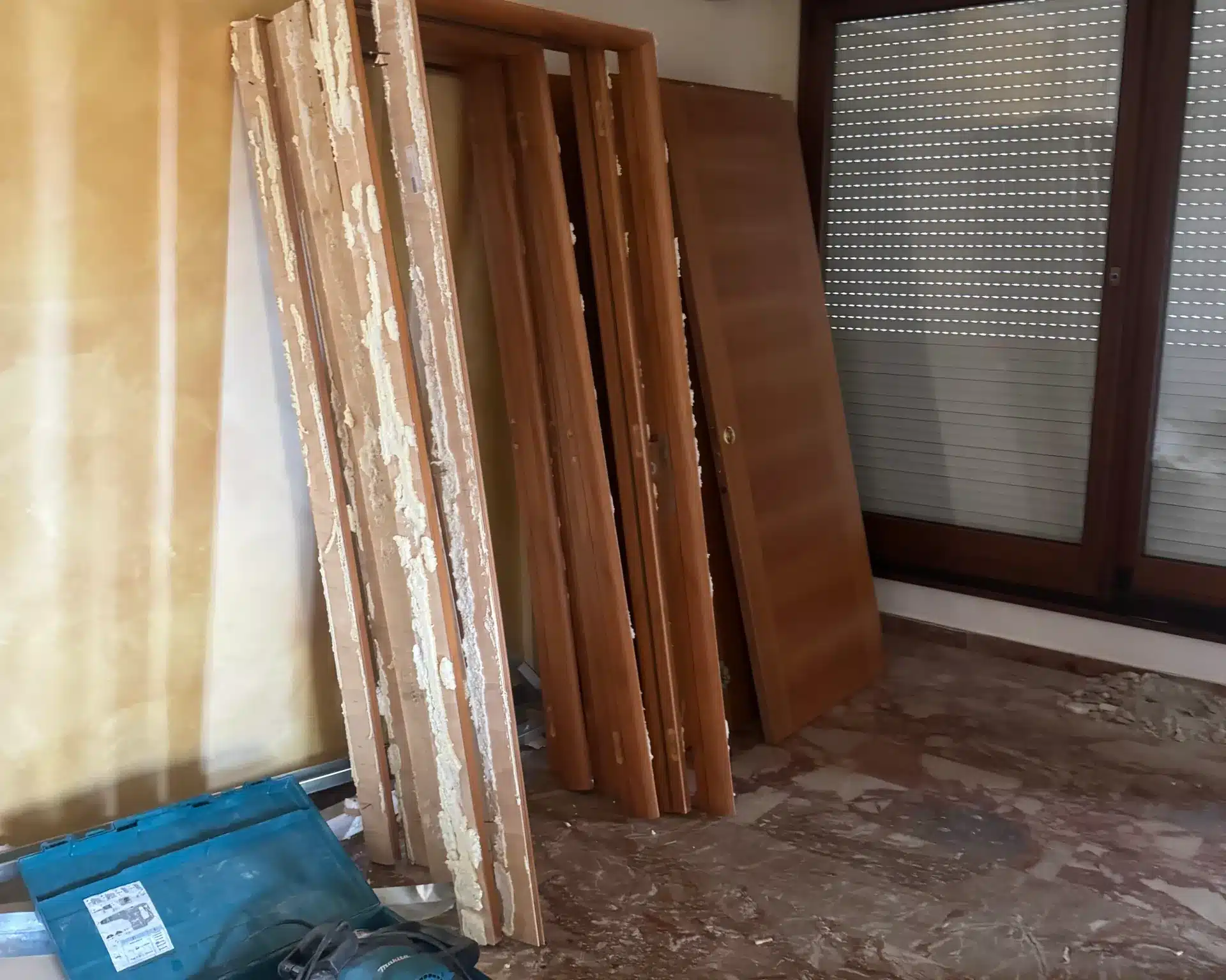 Ambiente interno durante i lavori, con serramenti smontati e attrezzatura di cantiere