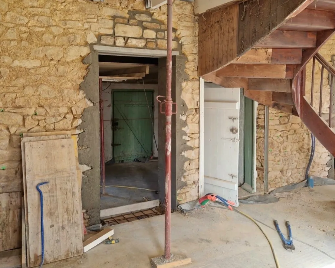 Ambiente con muri in pietra e scala in ferro in fase di recupero