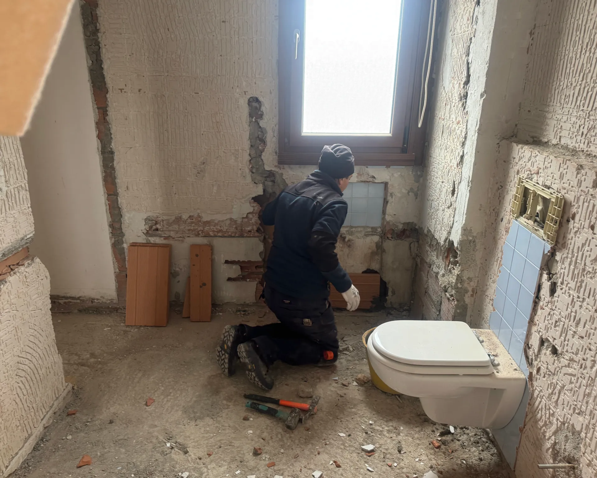 Operaio al lavoro sugli scarichi di un bagno in ristrutturazione
