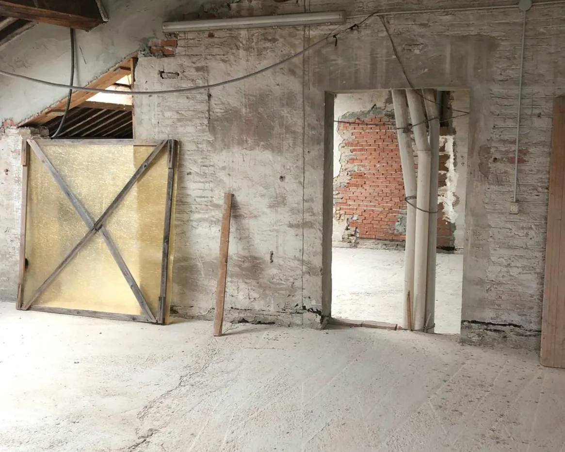 Sottotetto in mattoni con travi in legno durante i lavori di ristrutturazione